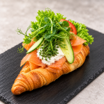 Røget laks med rygeostcreme - Laks, Hjemmelavet rygeostcreme, frisk agurk, tomat og purløg. En frisk og delikat croissant med masser af smag.